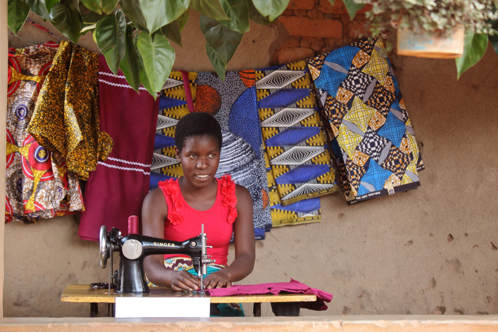 Rebecca, 21, sewing at her show, Malawi