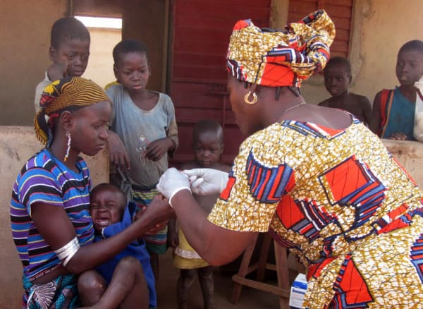 Madeleine, 35, testing a baby for malaria on a home visit, Benin
